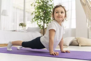 Bambina si cimenta in posizioni di yoga per bambini